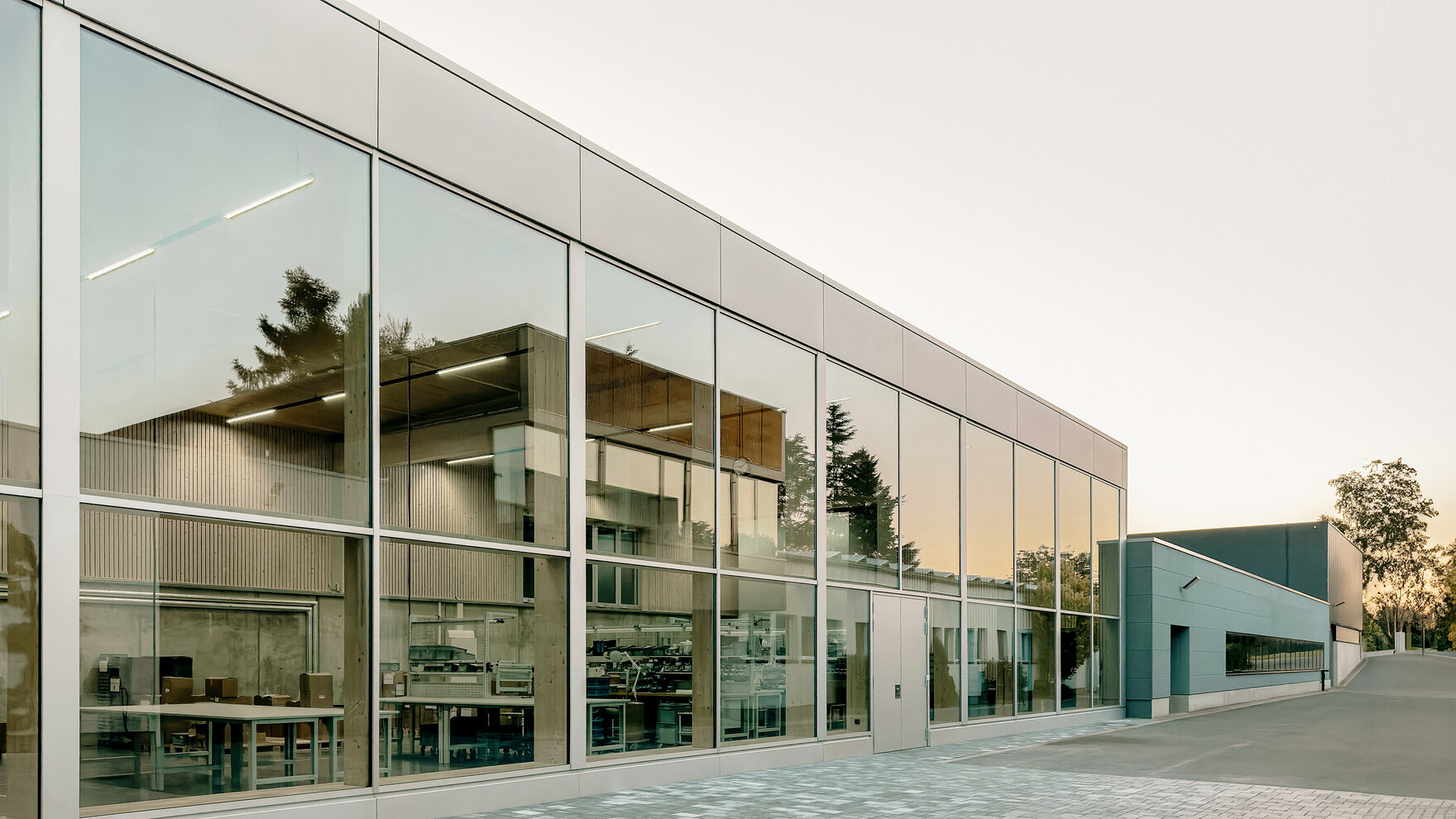 Gebäude mit Glasfront in der sich ein weiteres Gebäude spiegelt