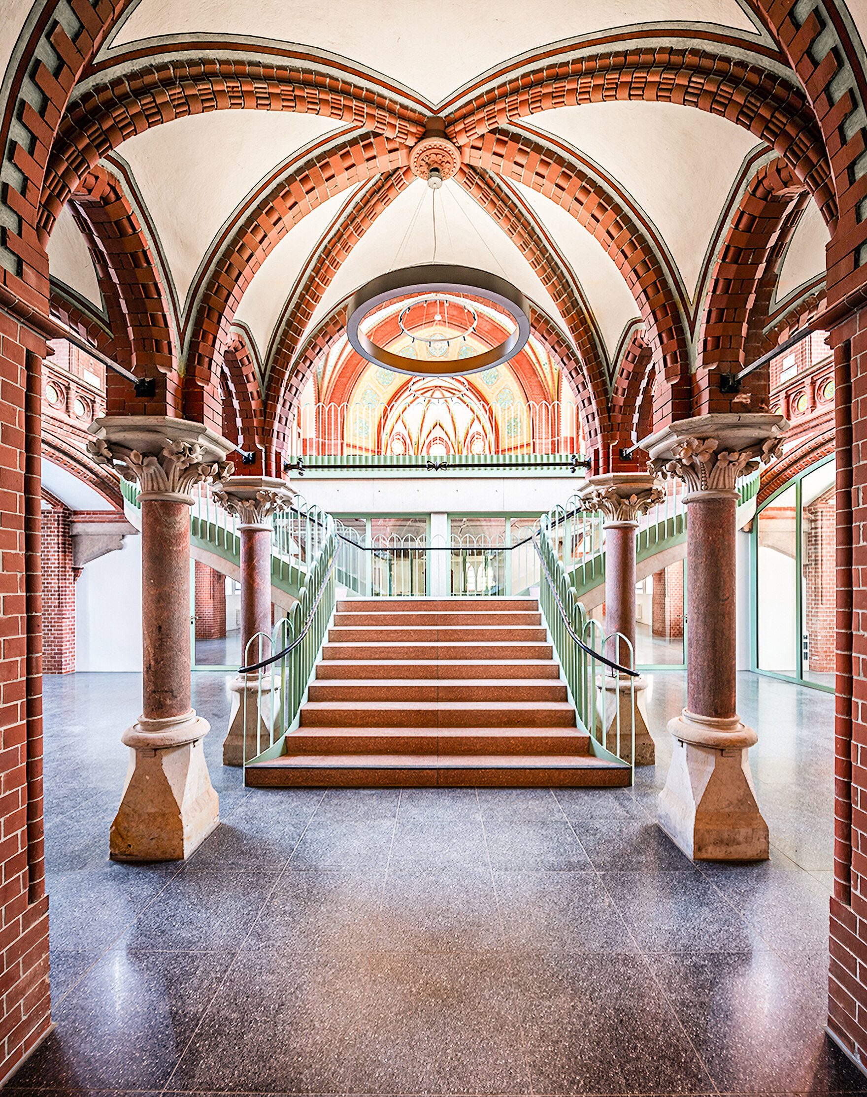Kircheninnenraum mit freischwebender Treppe, rot-weißer Kuppel