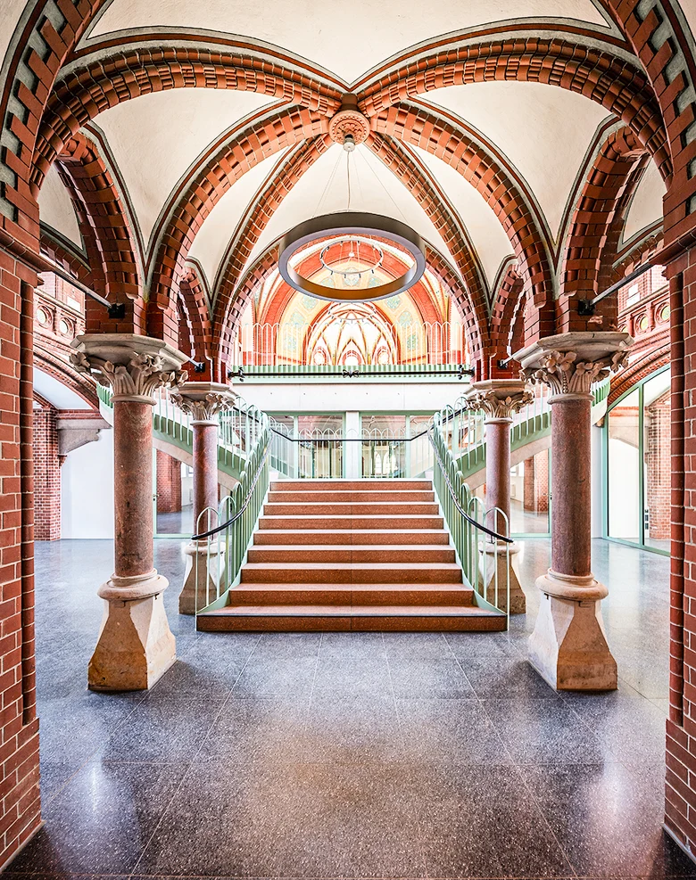 Kircheninnenraum mit freischwebender Treppe, rot-weißer Kuppel