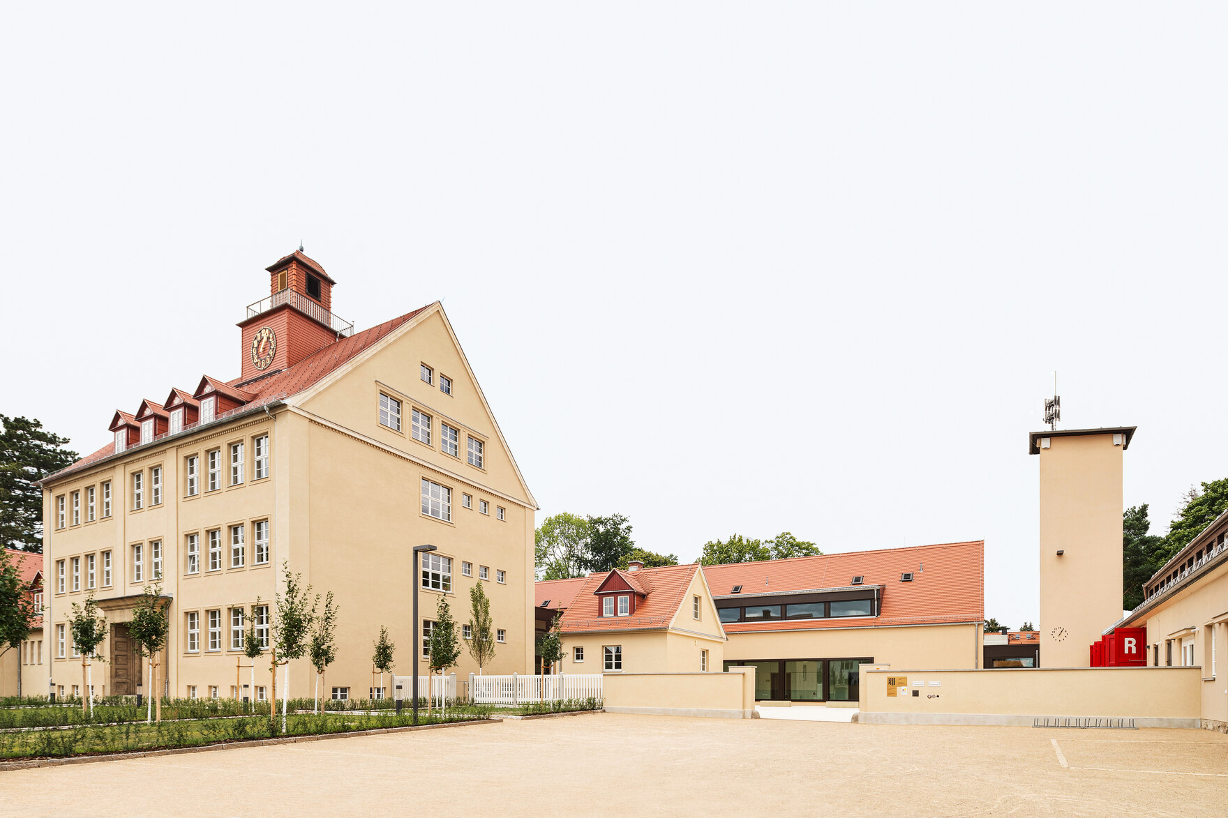 Gebäudekomplex gelb mit roten Dächern, ein Gebäude mit Uhr-Turm